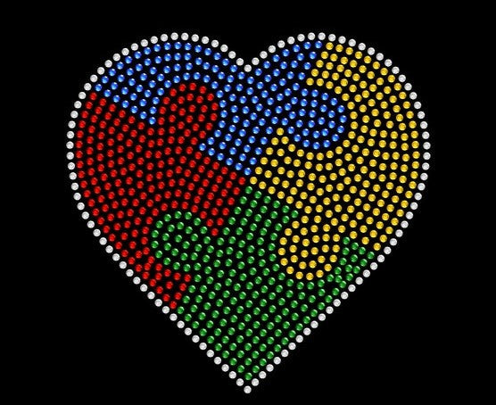 Embrace Difference Tees -Small Heart - Tumble into Love  Close up of the heart.  Heart has 4 colors blue, yellow, red and green. puzzle pieces.  Heart is outlined in sliver rhinestones.