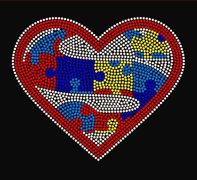 Embrace Difference Tees -Superhero Heart - Tumble into Love.  Close up of the design.  Heart has an "S" for Superhero and is made up of Red, Blue, yellow puzzle pieces,  Entire heart design is made of colorful rhinestones. 