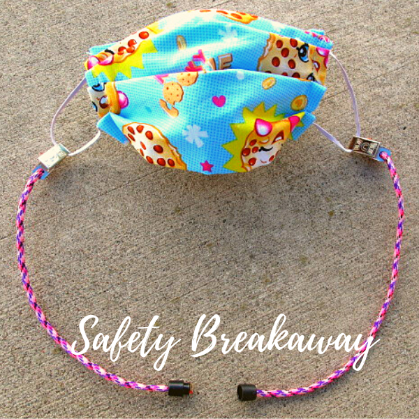Image of a mask with the cotton candy mask lanyard attached.  Cotton candy color is an argyle pattern with pink, white and purple.  Image shows the safety breakaway opened.