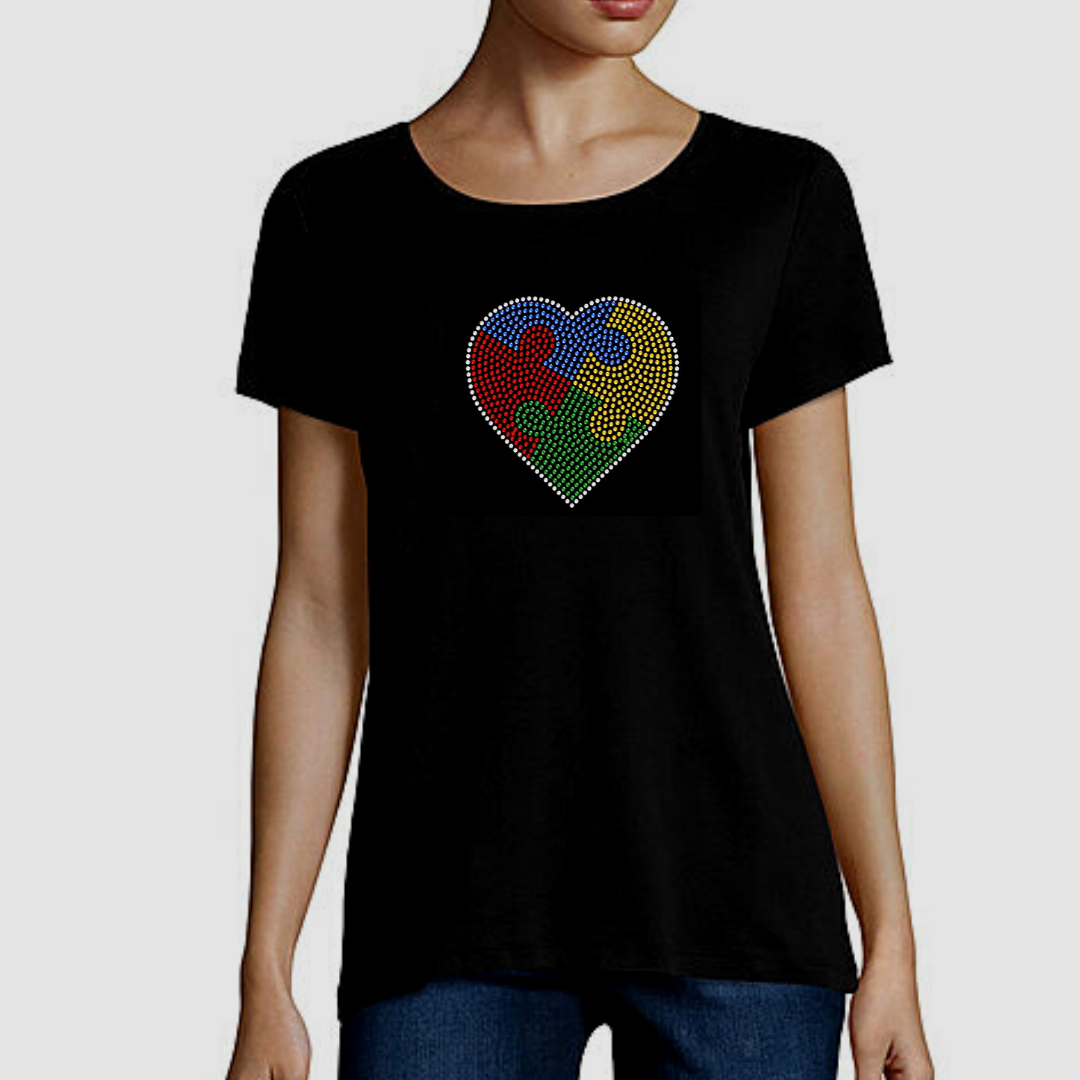 Embrace Difference Tees -Small Heart - Tumble into Love.  Black short sleeved tee shirt with small heart.  Heart has 4 colors blue, yellow, red and green. puzzle pieces.  Heart is outlined in sliver rhinestones.
