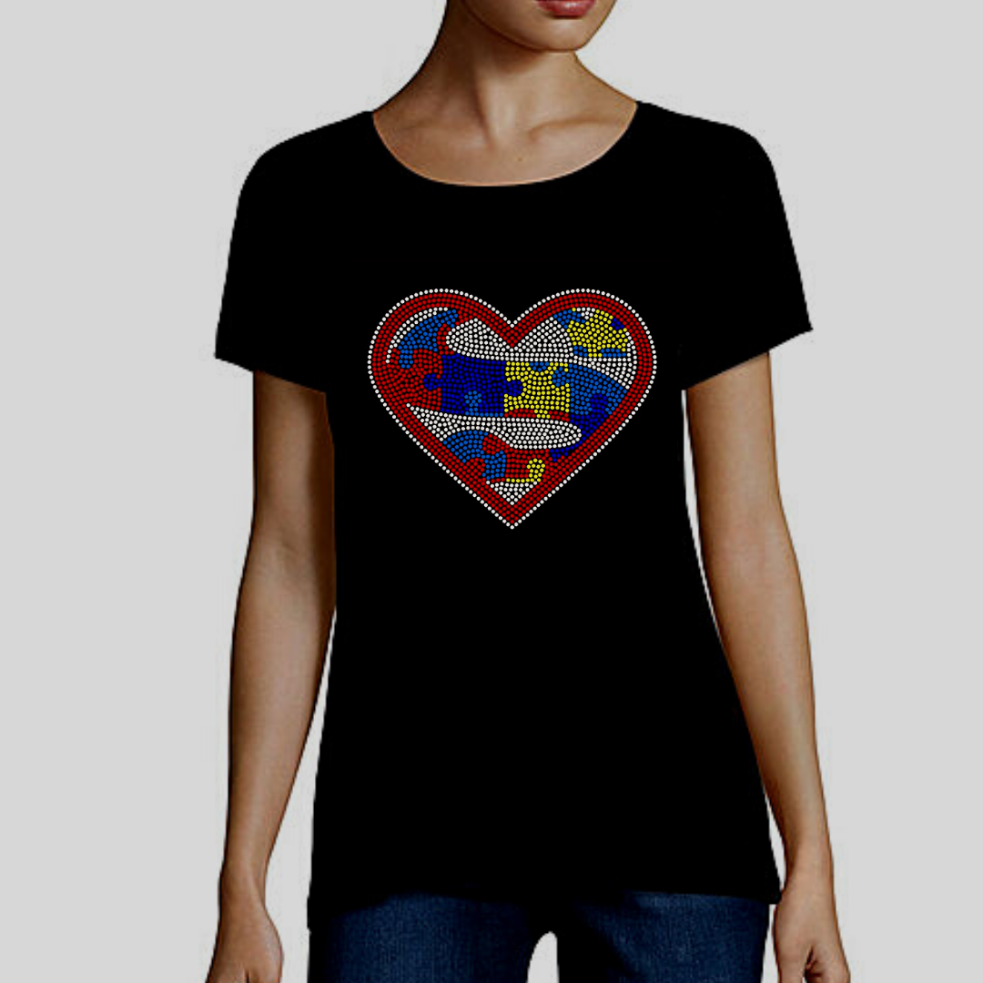 Embrace Difference Tees -Superhero Heart - Tumble into Love.  Short sleeved black tee shirt with a large heart.  Heart has an "S" for Superhero and is made up of Red, Blue, yellow puzzle pieces,  Entire heart design is made of colorful rhinestones.