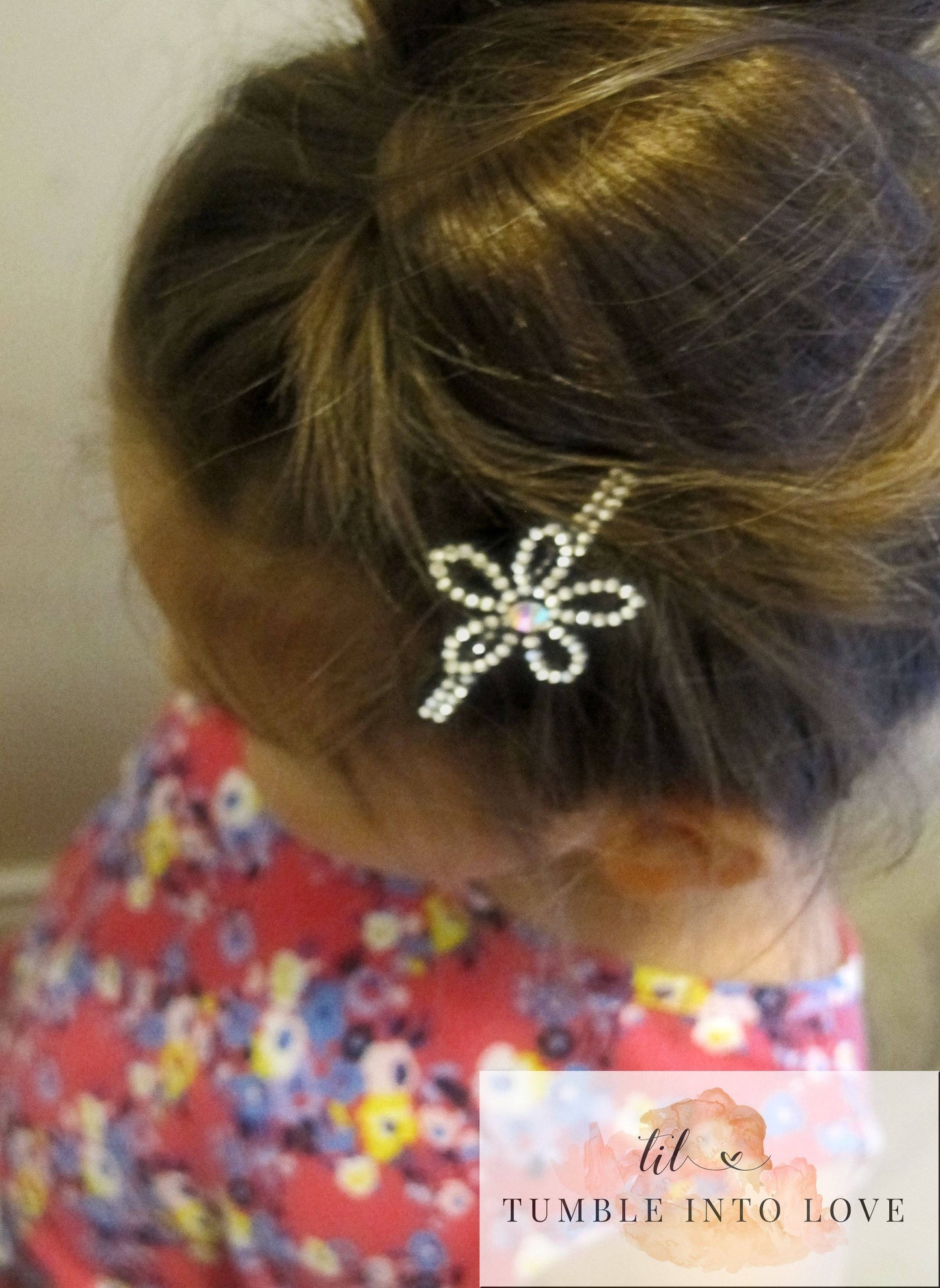 Image shows flower style clip in a child's hair.