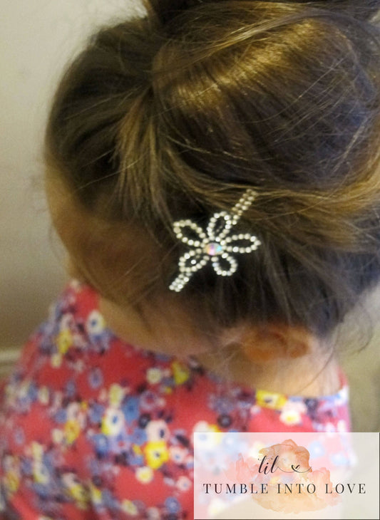Image shows flower style clip in a child's hair.