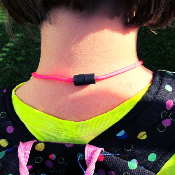 Image of the back of a person's neck showing the safety breakaway on the mask lanyard.