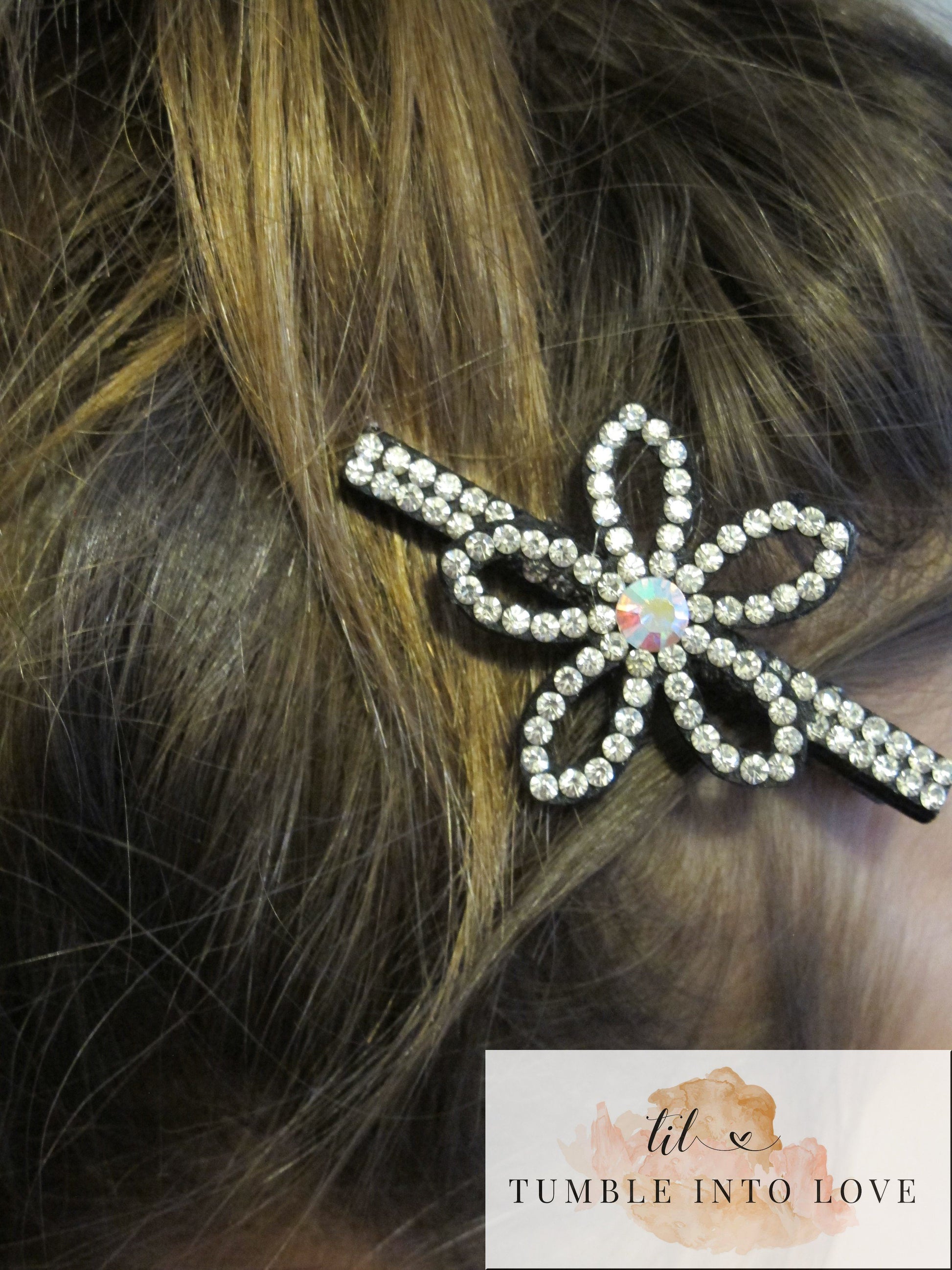 Up close image of flower style rhinestone clip in brown hair.