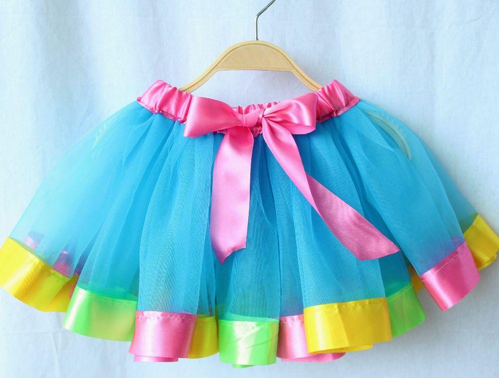 Image showing the rainbow tutu which is aqua blue with pink ribbon at the top, and multi colored ribbon at the bottom, including pink, yellow, and green. 